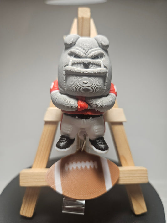 Grey bulldog badge reel charm with football and red collar; clip visible below