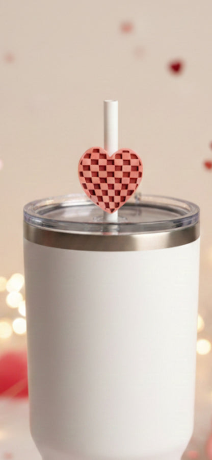 White tumbler with a heart-shaped straw cover on a blurred background